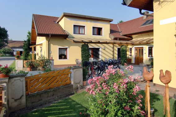 Vacation apartments & private rooms Leeb, © Privatzimmer Leeb Yellow house with garden and bicycles in front of the door.