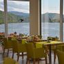 Fish restaurant Landmotel 'Die Donaurast', © Fam. Nimführ Interior view of a restaurant with a view of a river and green hills.