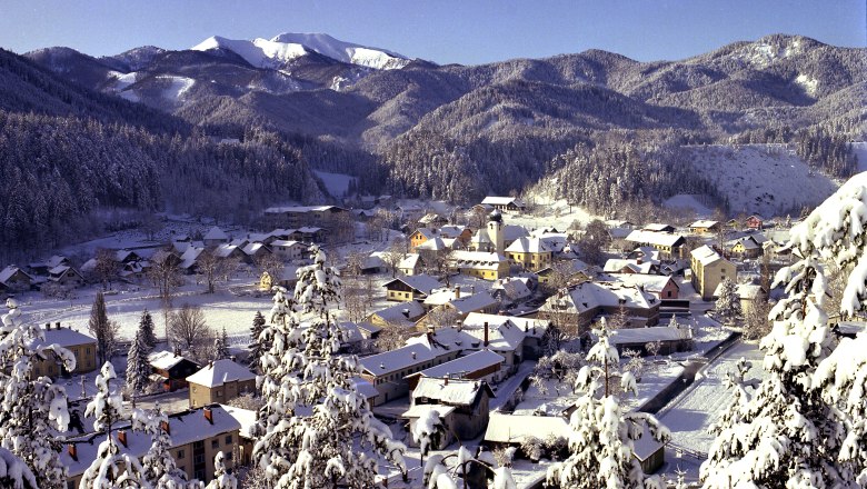 St. Aegyd from the Osterkogel, © ARGE Genusstourismus St. Aegyd Winter landscape of St. Aegyd with snow-covered houses and mountains in the background.