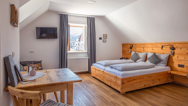 Apartment house Leopold an der Ybbs, © Niederösterreich Werbung / Maximilian Pawlikowsky Cozy bedroom with wooden furniture and sloping ceiling.