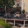 Bike-friendly inn on the Danube cycle path, © Niederösterreich Werbung/Daniela Führer Cozy terrace of a café with wooden tables and chairs, surrounded by plants.