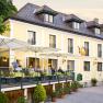 Country inn 'Zur Schönen Wienerin', © Engel A yellow country inn with a terrace and parasols where people are sitting.