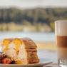 Cardinal slices with a view of the Danube, © Niederösterreich Werbung/Daniela Führer Piece of cake with strawberries and latte macchiato by the lakeside.