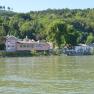 Wasse estate, © manfred nimführ Houses on the riverbank with a wooded hill in the background.