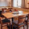 Bright guest room to make you feel at home, © Niederösterreich Werbung/Daniela Führer Cozy restaurant with wooden tables and upholstered benches.