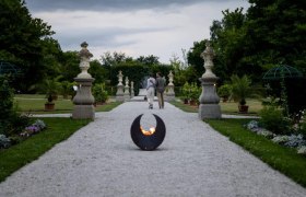 Historic courtyard garden Seitenstetten Abbey, © Unrath A gravel path in the historic courtyard garden of Seitenstetten Abbey with sculptures and plants, a fireplace in the foreground.