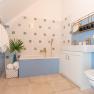 Old post office bathroom, © Aumüller Caroline Modern bathroom with blue walls, bathtub, washbasin and golden fittings.