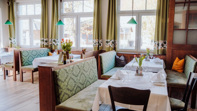 Modern guest room, © Niederösterreich Werbung/thecreatingclick.com Cozy restaurant with green benches and table decorations.