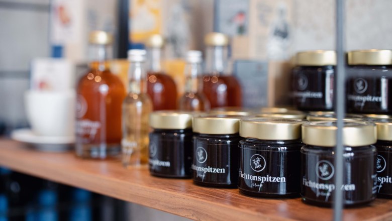 Products in the Taflerei store, © Hotel Schachner_MIKU Media Shelf with glasses and bottles in the Taflerei store.