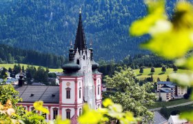 Mariazell Basilica, © weinfranz.at Mariazell Basilica in front of wooded hills and blossoming trees.
