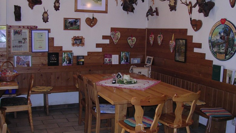 Holzhof snack station, © Holzhof Cozy parlor with wooden furniture and hunting trophies on the walls.
