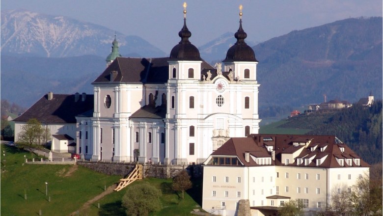 Basilica Sonntagberg, © Gemeinde Sonntagberg Sonntagberg basilica on a hill with mountains in the background.