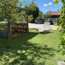 Pergola, © Privatzimmer Leeb Garden with pergola, wooden table and chairs, sun lounger on lawn, cars in the background.