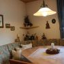 Breakfast room, © Haus Regina Cozy breakfast room with corner bench, table, candle and decorations on the wall.