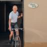 Bike garage, service, rental, tours, © Niederösterreich Werbung/Daniela Führer Man riding a bicycle out of a garage with a 'bicycle garage' sign.