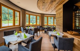 Restaurant, © Christian Kremsl Elegant restaurant with wooden elements, laid tables and large windows overlooking the greenery.