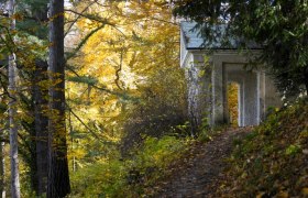 Autumn scene in Lilienfeld Abbey Park with foliage and a small building.