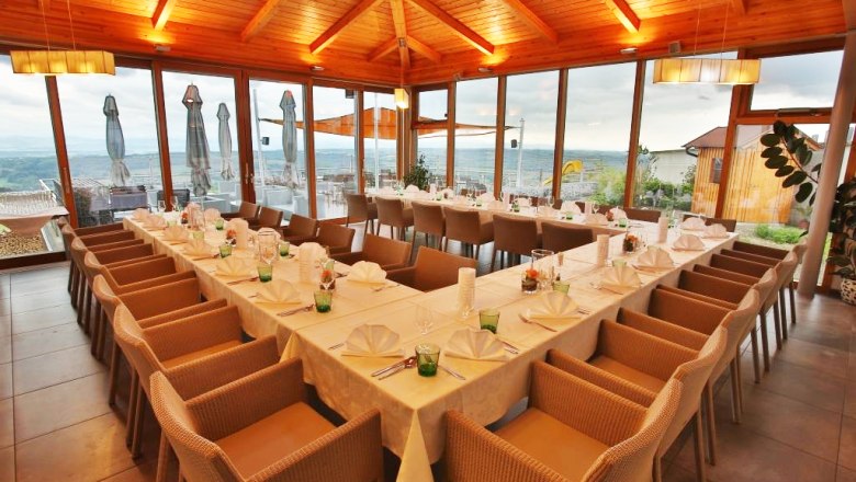 Interior view of a restaurant with set tables and panoramic windows.