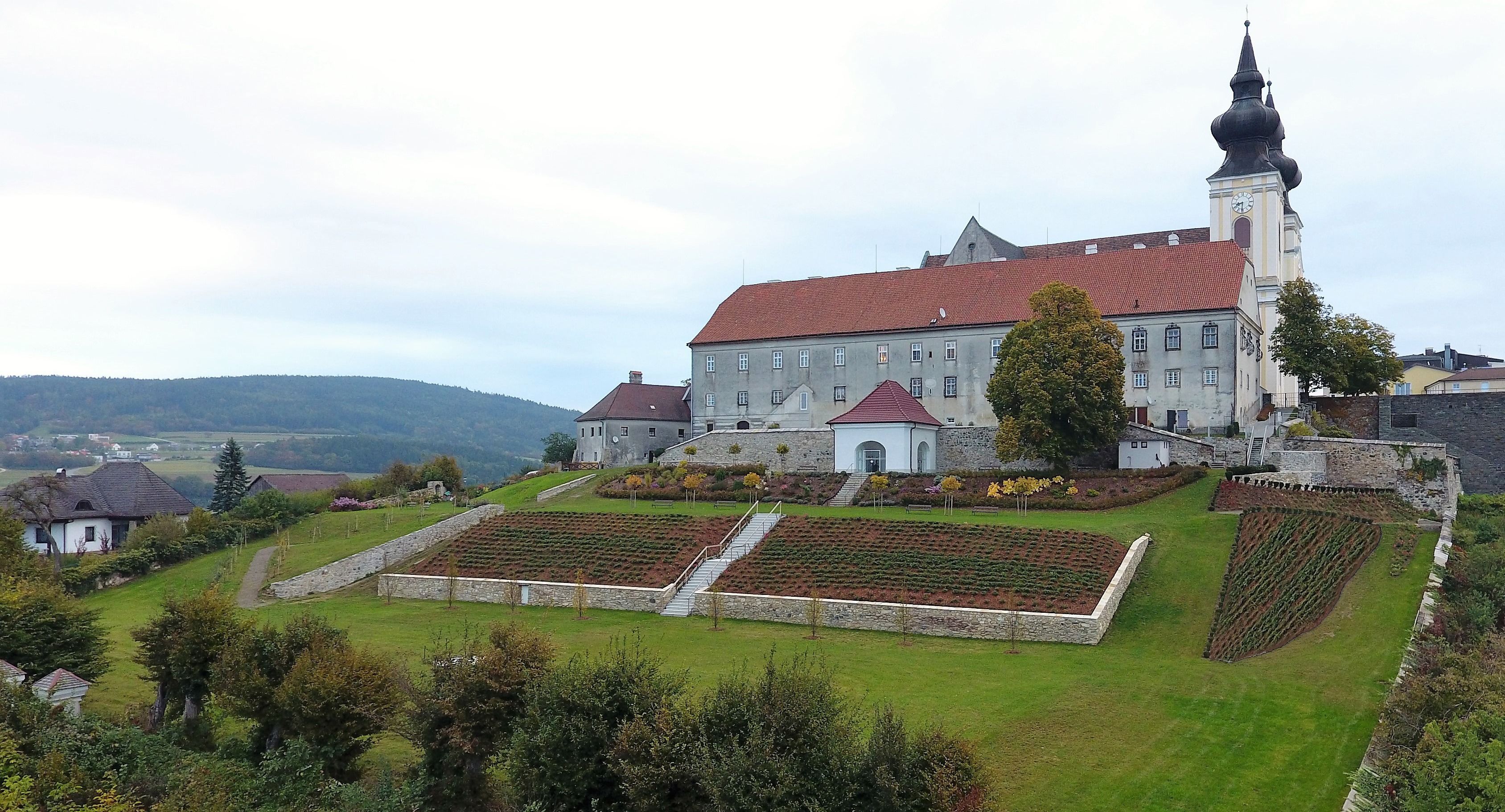 Landscape with church and gardens on a hill.