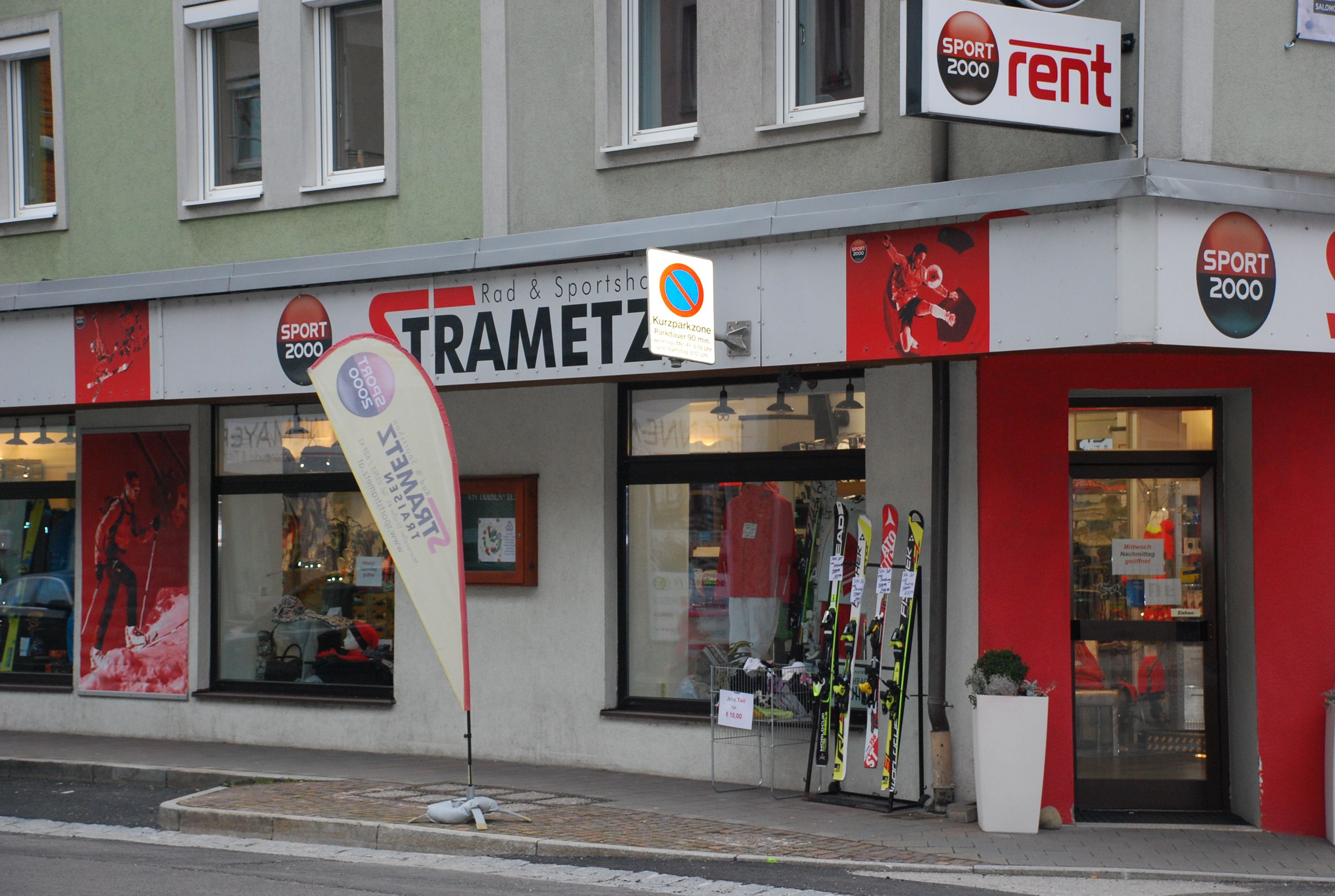 Exterior view of a sports store called Strametz with skis and sportswear in the shop window.