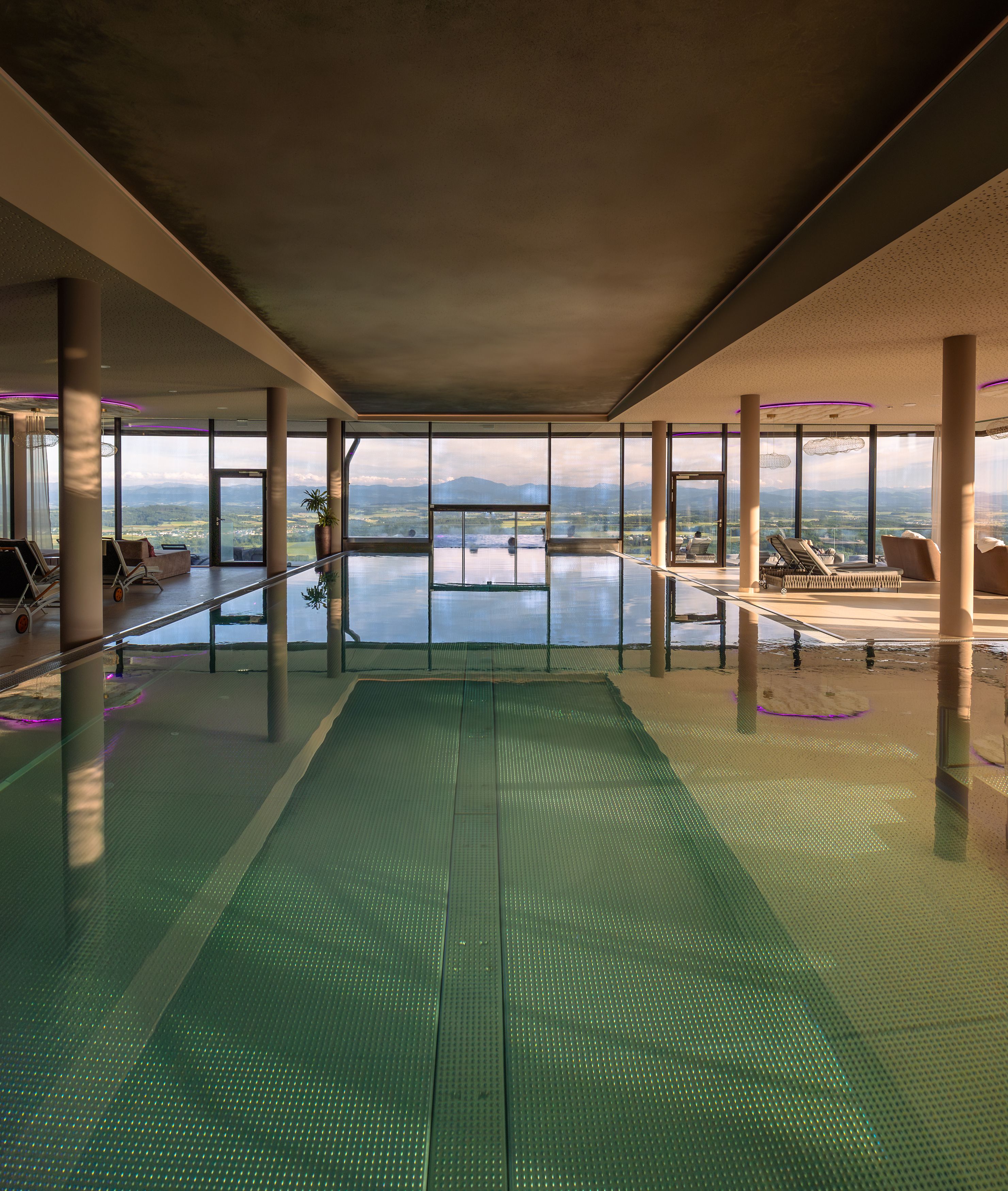 Indoor pool with panoramic views of the mountains and countryside.