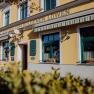 Yellow inn 'Zum Goldenen L&ouml;wen' with green shutters and flower boxes.
