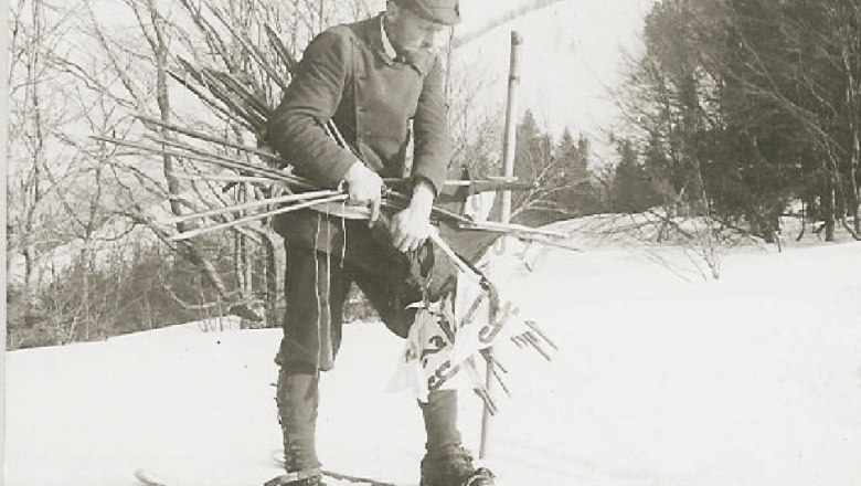 Historical photograph of a man on skis with ski poles in the snow.