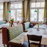Cozy restaurant with green benches and table decorations.