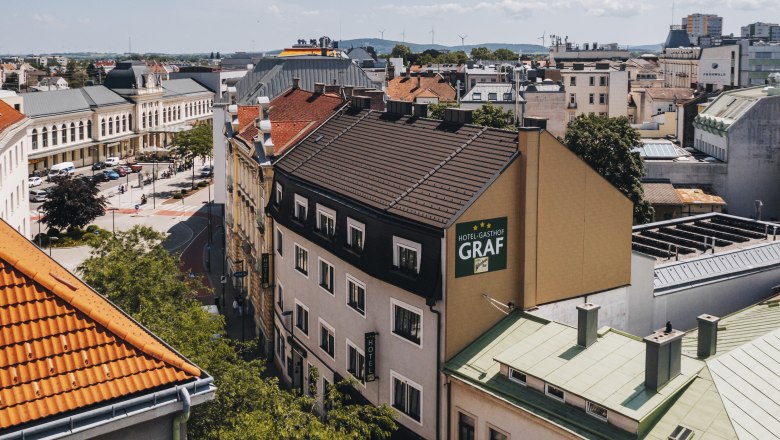 Hotel-Gasthof in the center of St. Pölten, © Niederösterreich-Werbung/David Schreiber Aerial view of a hotel-inn in St. Pölten with surrounding buildings and streets.