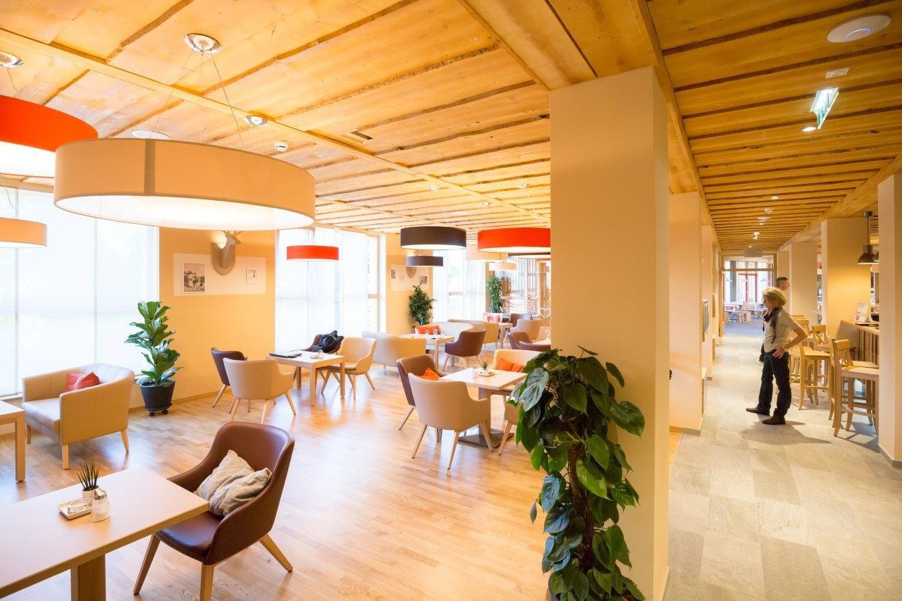 Lobby of the JUFA Hotel Annaberg with modern furniture and large lamps.