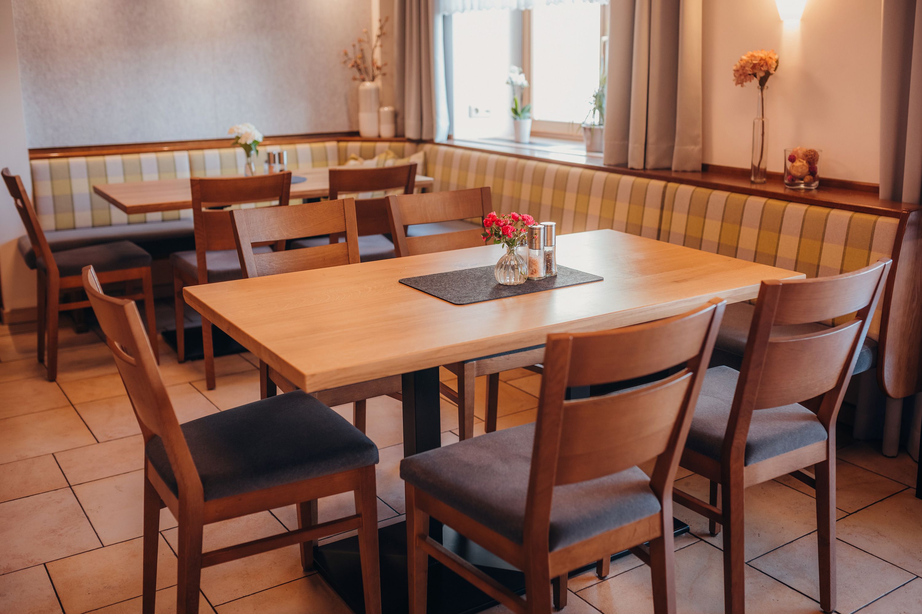 Cozy restaurant with wooden tables and upholstered benches.