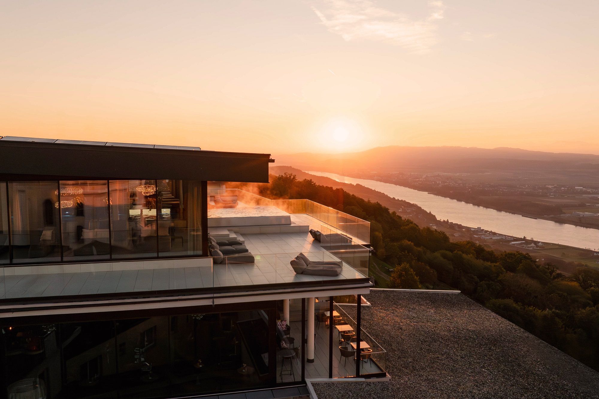 Modern hotel with terrace and river view at sunset and view over the Danube.