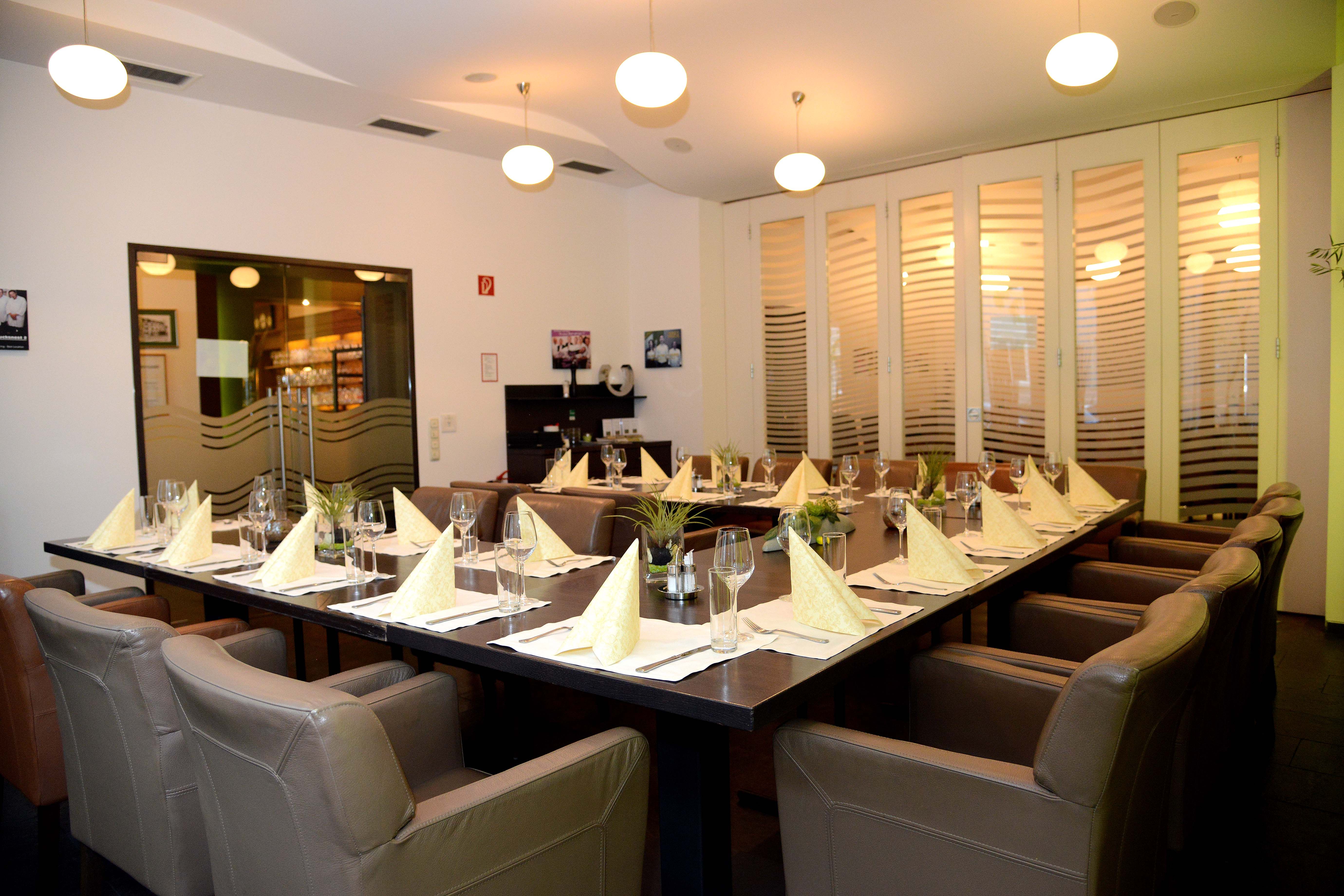 Elegant dining room with table setting and leather armchairs.