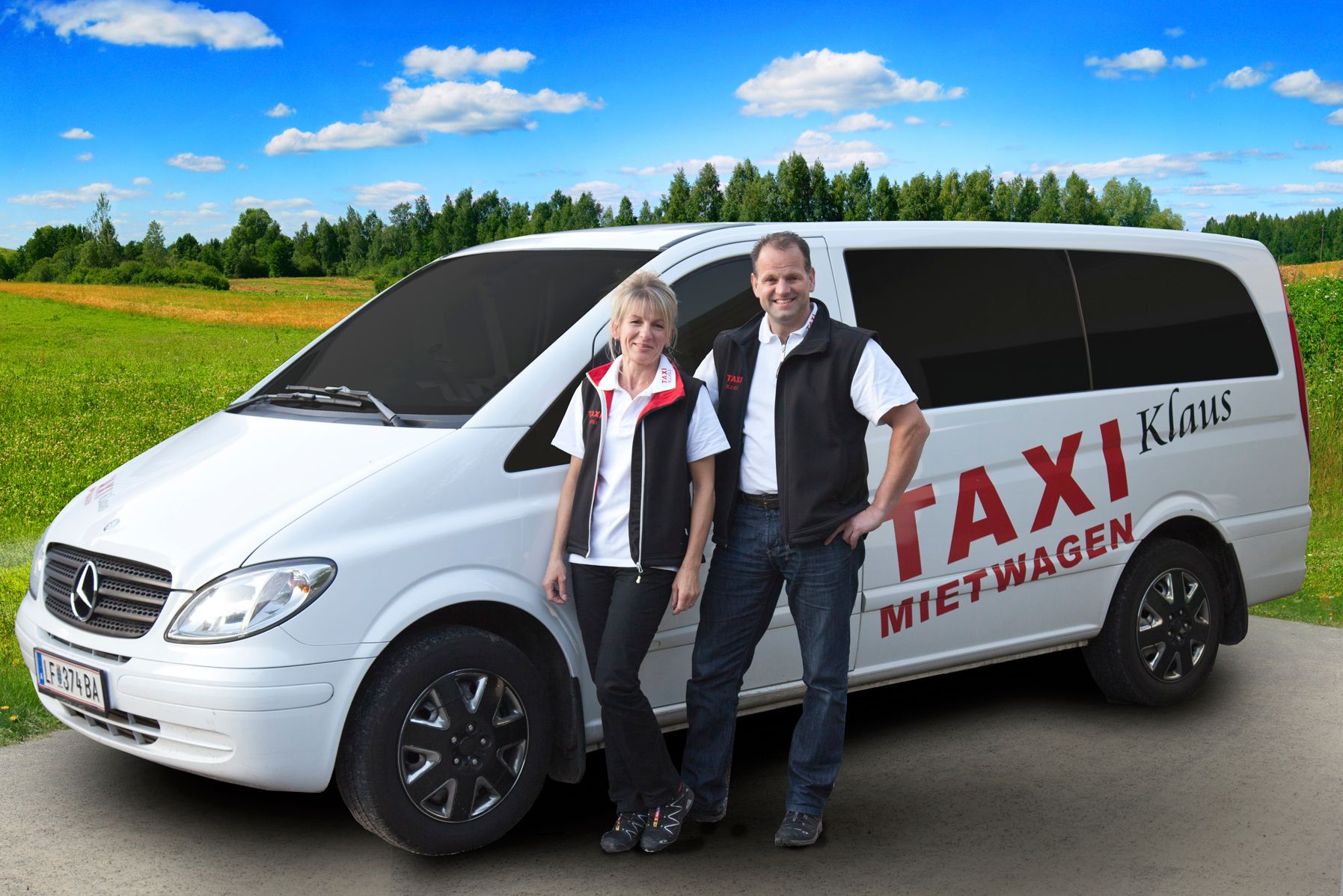 Two people are standing in front of a white Mercedes van labeled 'Taxi Mietwagen Klaus' on a rural road.