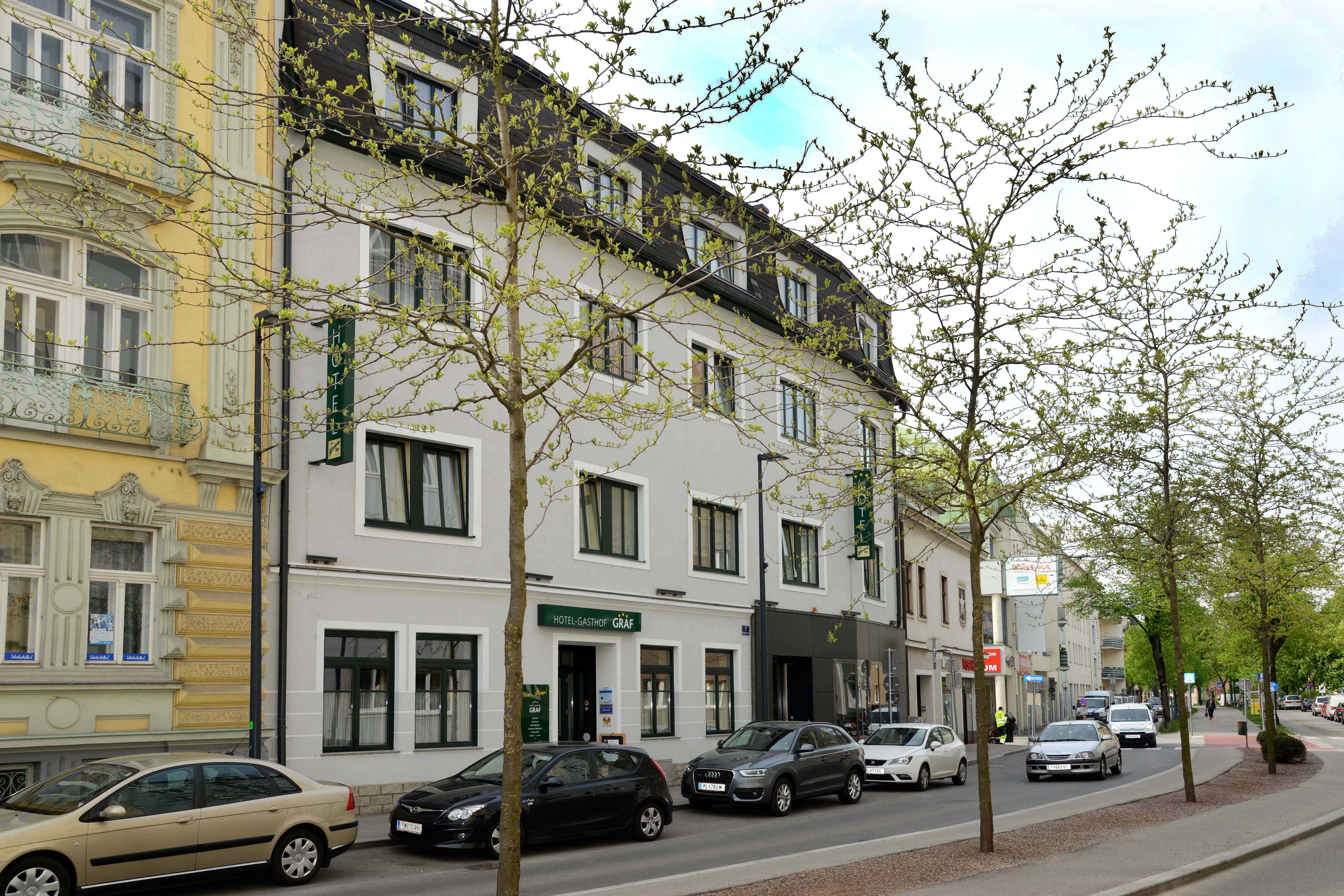Street view of the Hotel-Gasthof Graf with parked cars and trees.