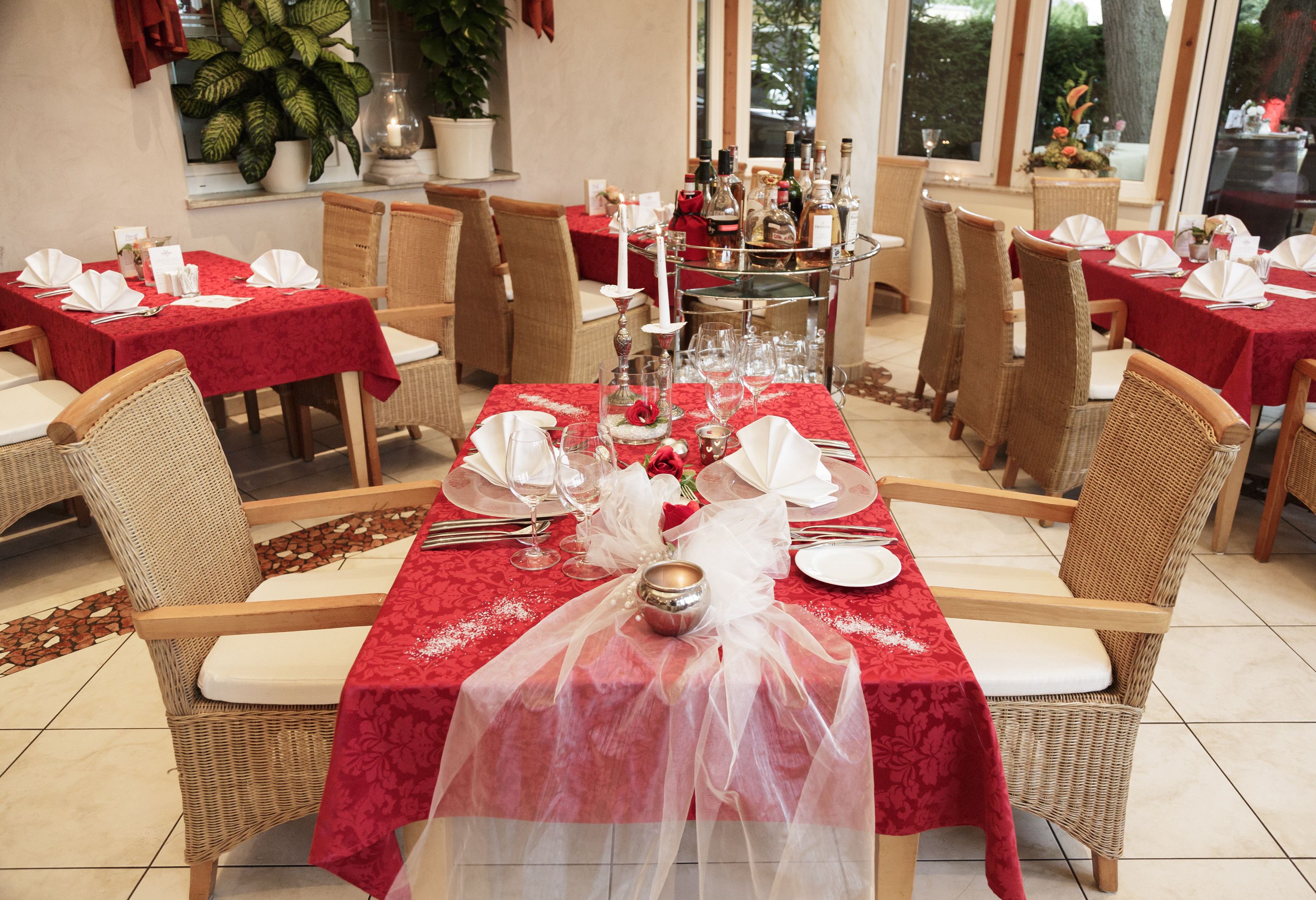Elegant restaurant with red tablecloths and laid tables.