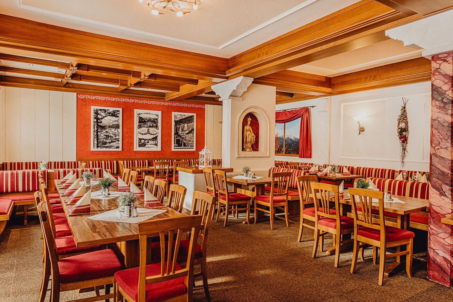 Cozy dining room with wooden furniture and red and white striped upholstery.