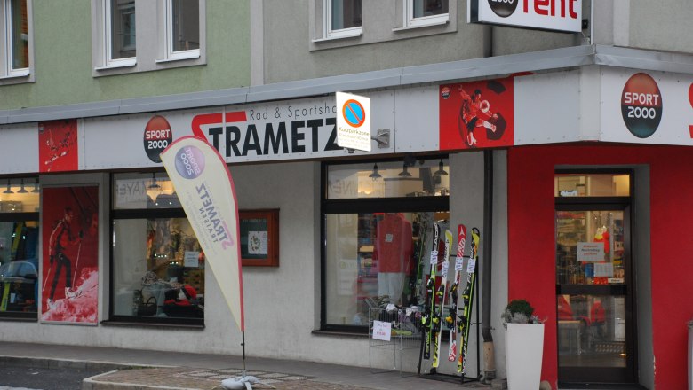 Exterior view of a sports store called Strametz with skis and sportswear in the shop window.