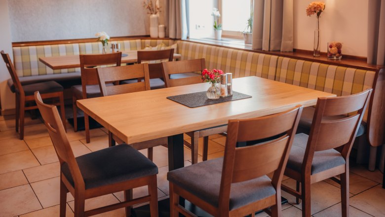 Cozy restaurant with wooden tables and upholstered benches.