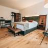 Modern hotel room with double bed, wooden floor and stylish furniture.