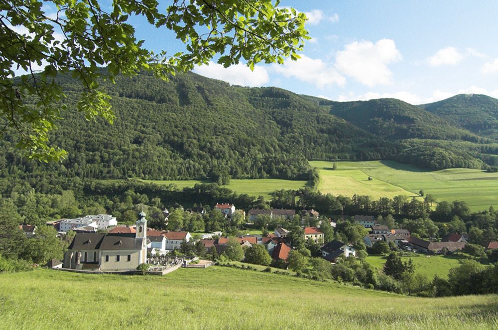 View of Altenmarkt with church and green landscape in the background.