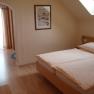 Cozy bedroom with double bed, skylight and wooden furniture.
