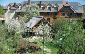 A hotel in the Dirndl Valley with blossoming trees and a garden.