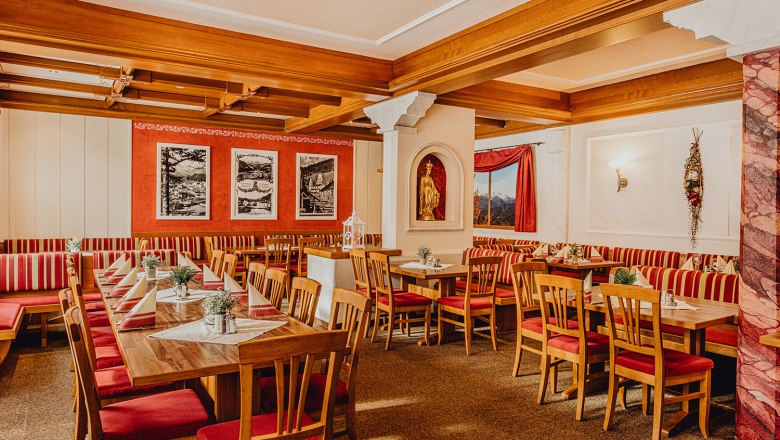Cozy dining room with wooden furniture and red and white striped upholstery.