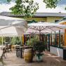 Outdoor area of a restaurant with tables, chairs and parasols.