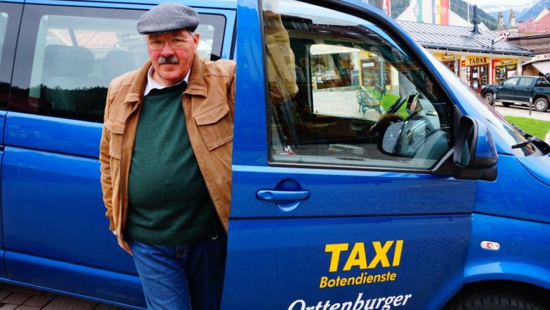 A man is standing next to a blue cab with the sign 'Taxi Botendienste Orttenburger'.