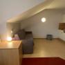 Interior view of a vacation apartment with sofa, table lamp and kitchenette.