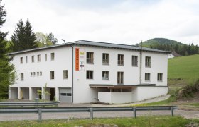 A white building with the inscription 'Brandtner' in a rural setting.