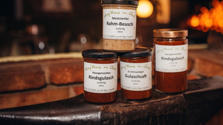 Three jars of ready meals on an anvil, labeled 'Wirtshaus im Glas'.