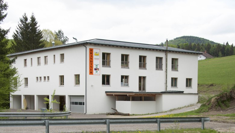 A white building with the inscription 'Brandtner' in a rural setting.